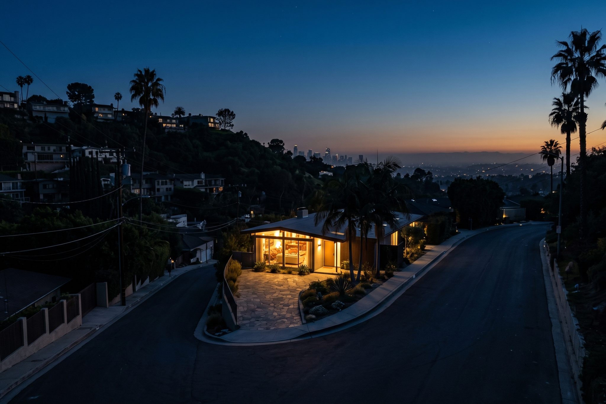 One lit house on a blacked-out street at night.
