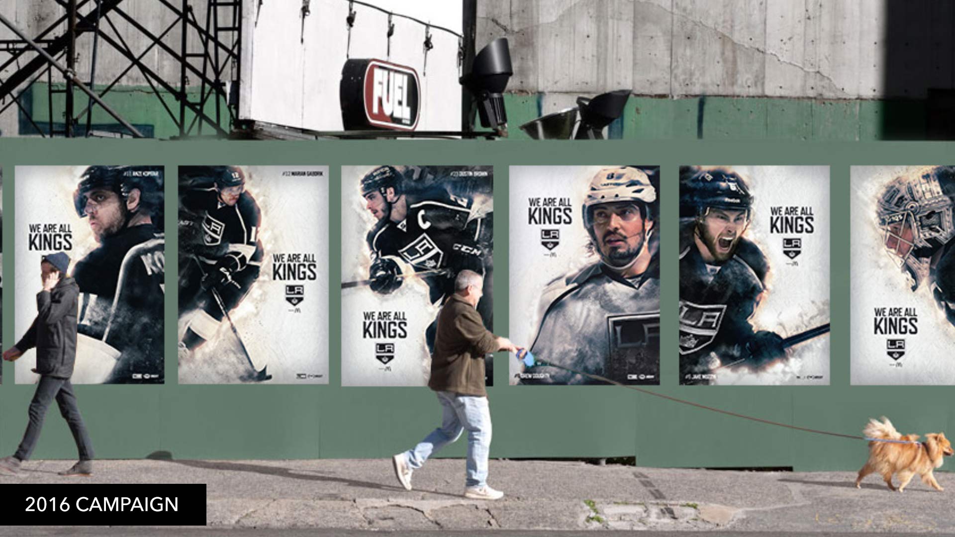 A city wall wild-posted with a row of We Are All Kings player posters
